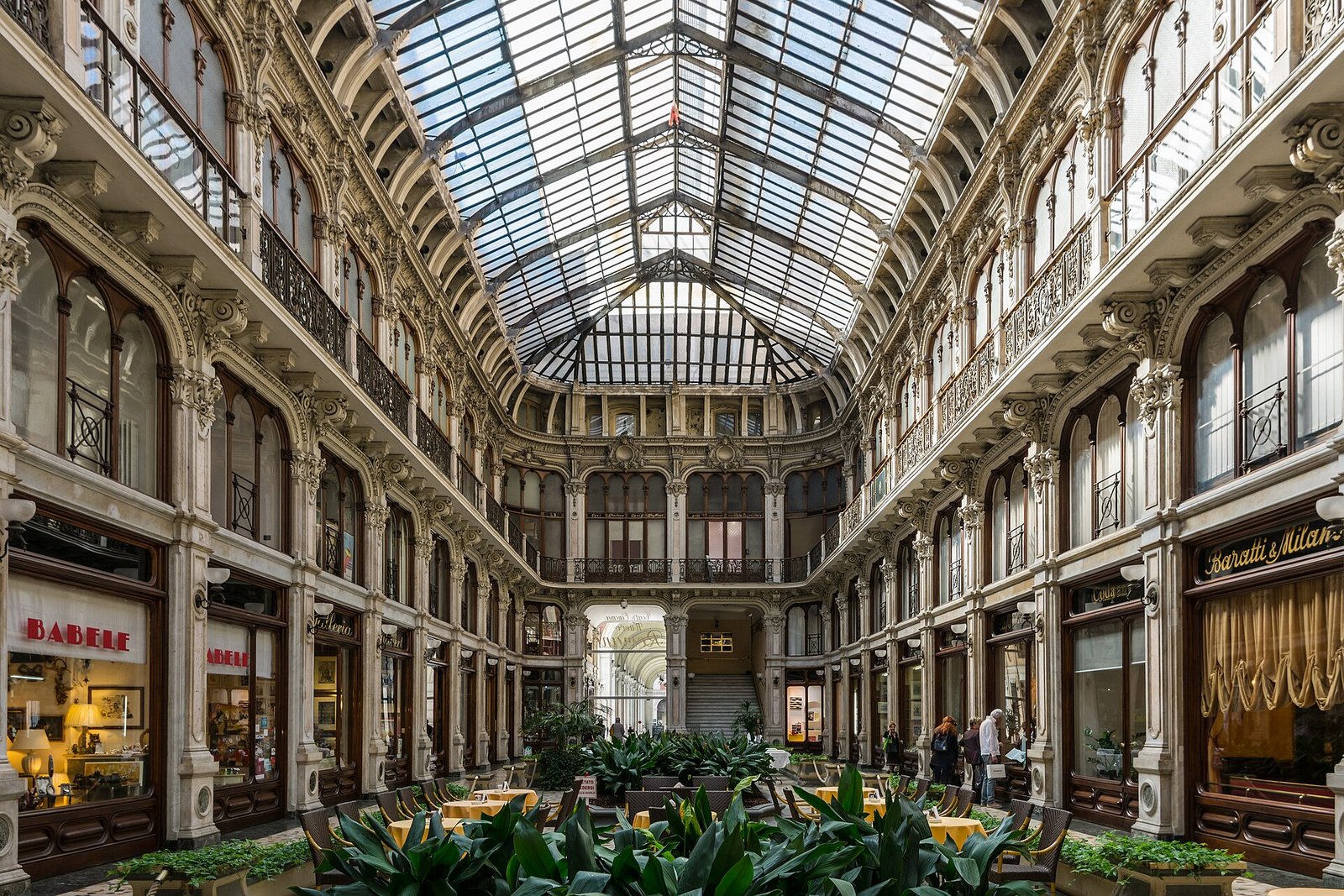 Die Galleria Subalpina in Turin mit Glasdach, verzierten Fassaden und Café-Tischen